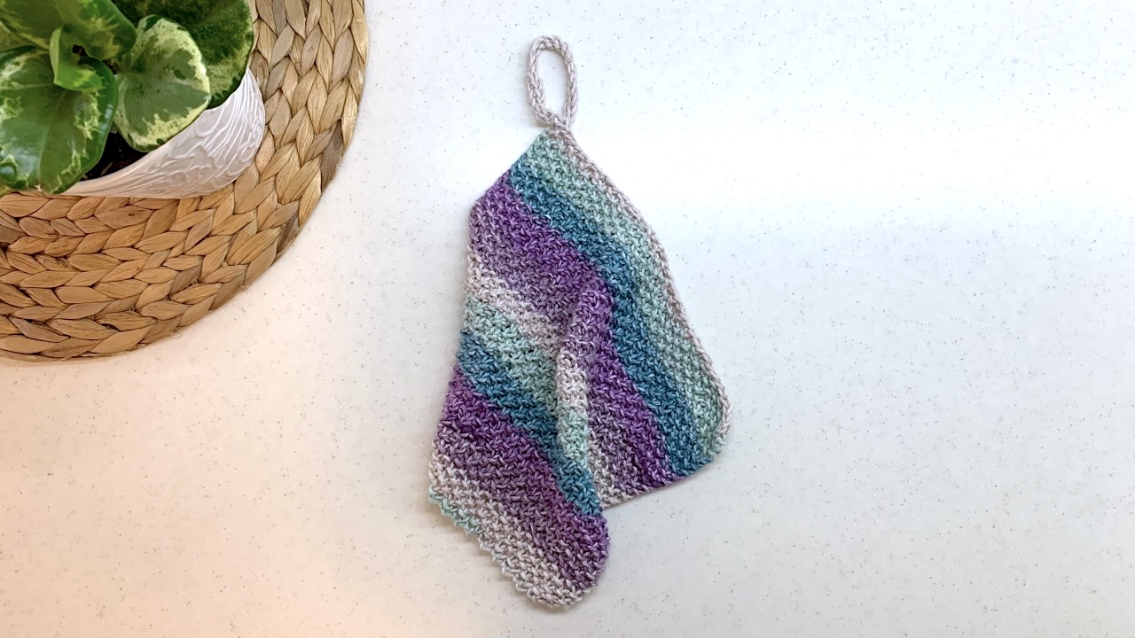 Knitted dishcloth featuring seed stitch and moss stitch in soft pastel colors