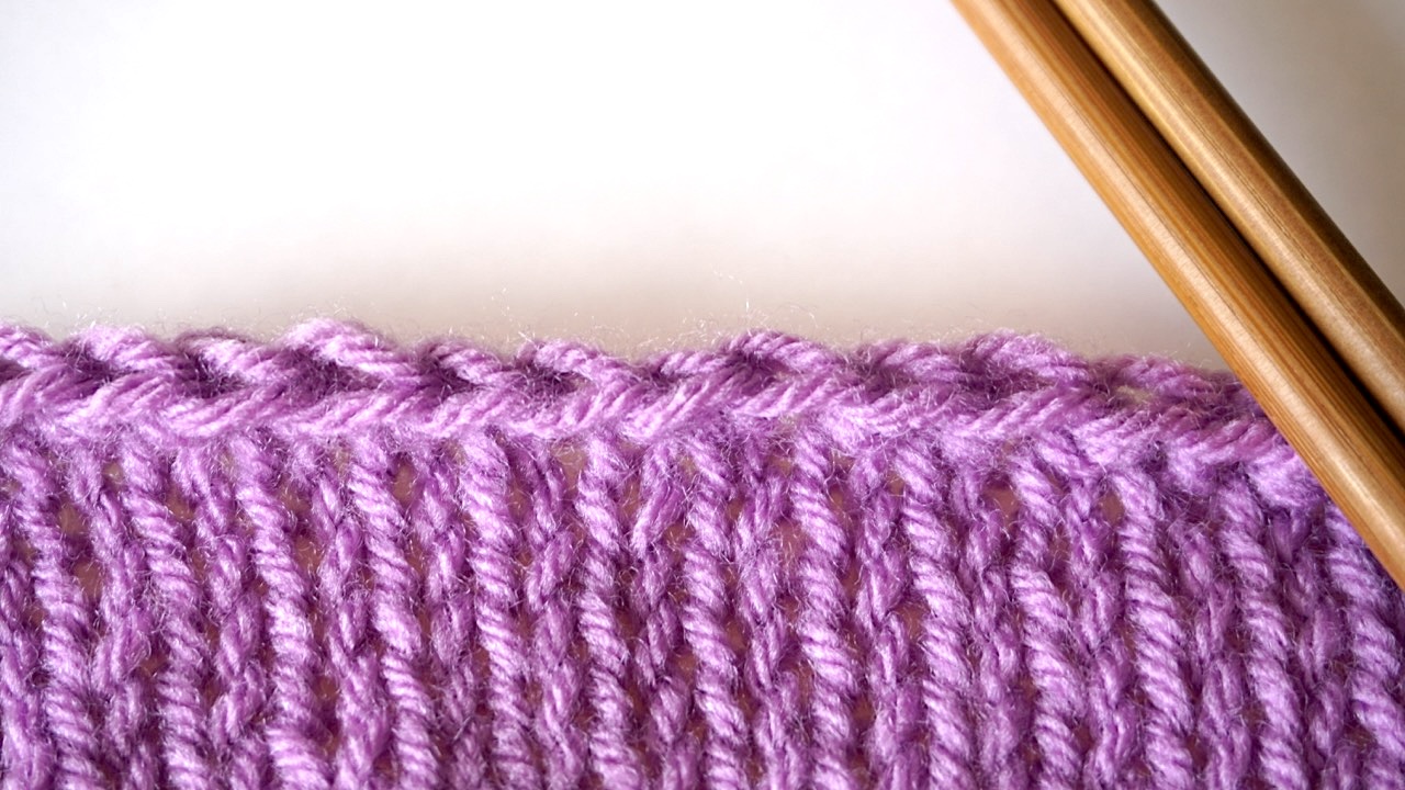 A knitted piece showing the bind off edge with Jeny's stretchy bind off stitches