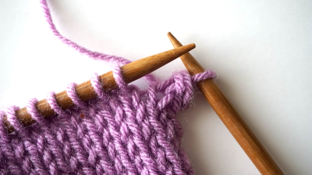 An unfinished knitting project with one Jeny's surprisingly stretchy bind off stitch on the right needle