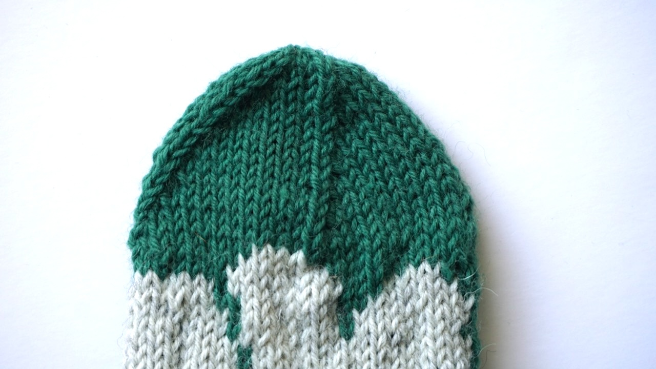 Close-up photo of a dark green knitted sock with star toe