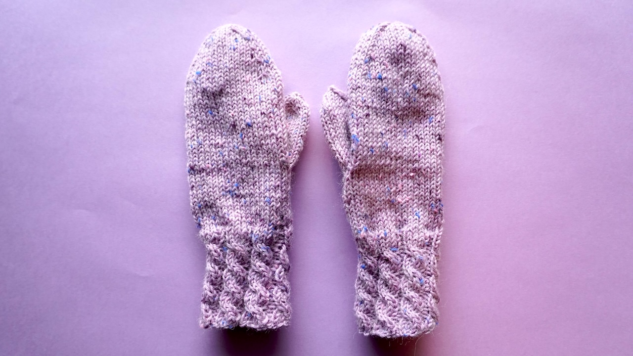 Knitted mittens featuring cable cuff and stockinette stitch body in purple yarn