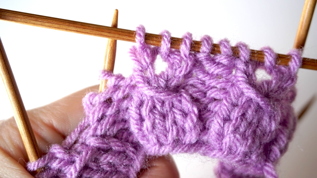 Step-by-step knitting photo showing needles with the finished mock cable knitting stitch