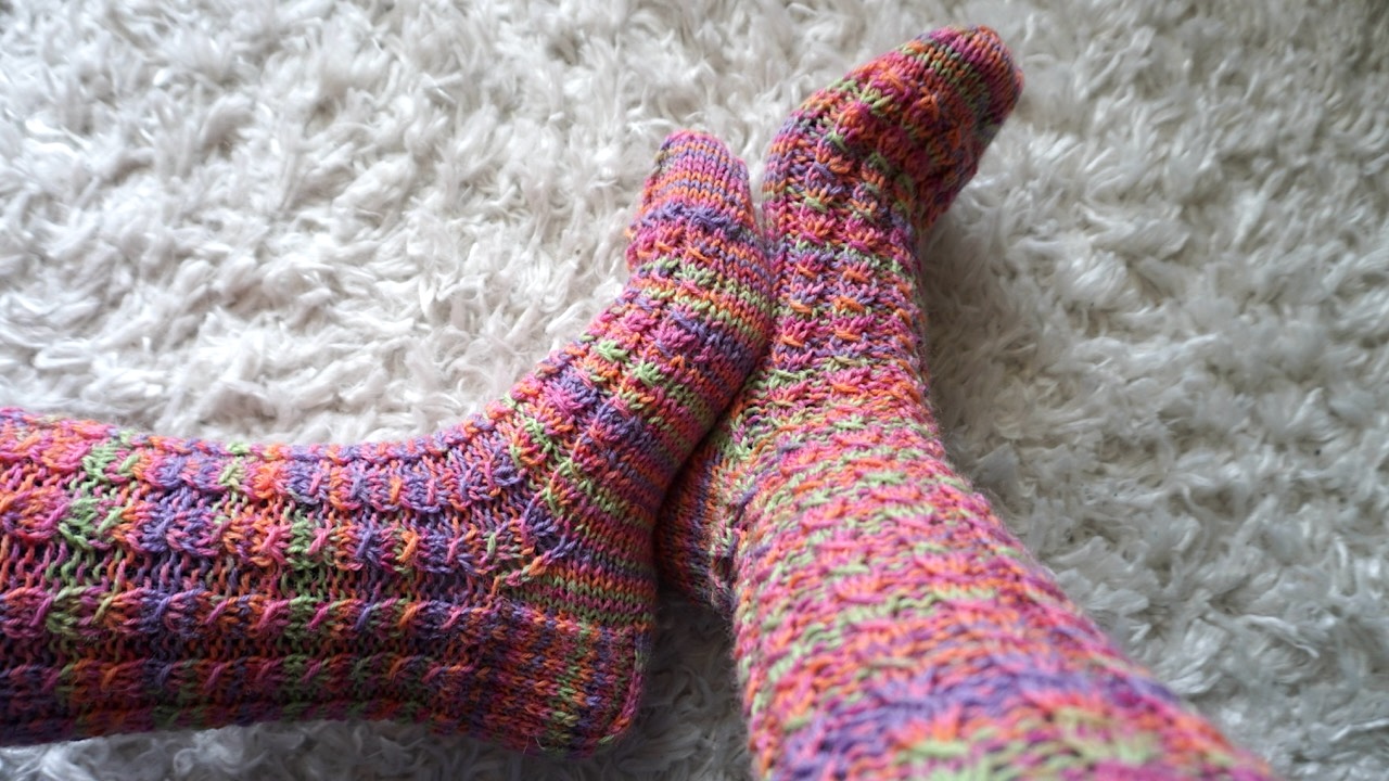 Knitted socks featuring mock cable stitch pattern in colorful yarn