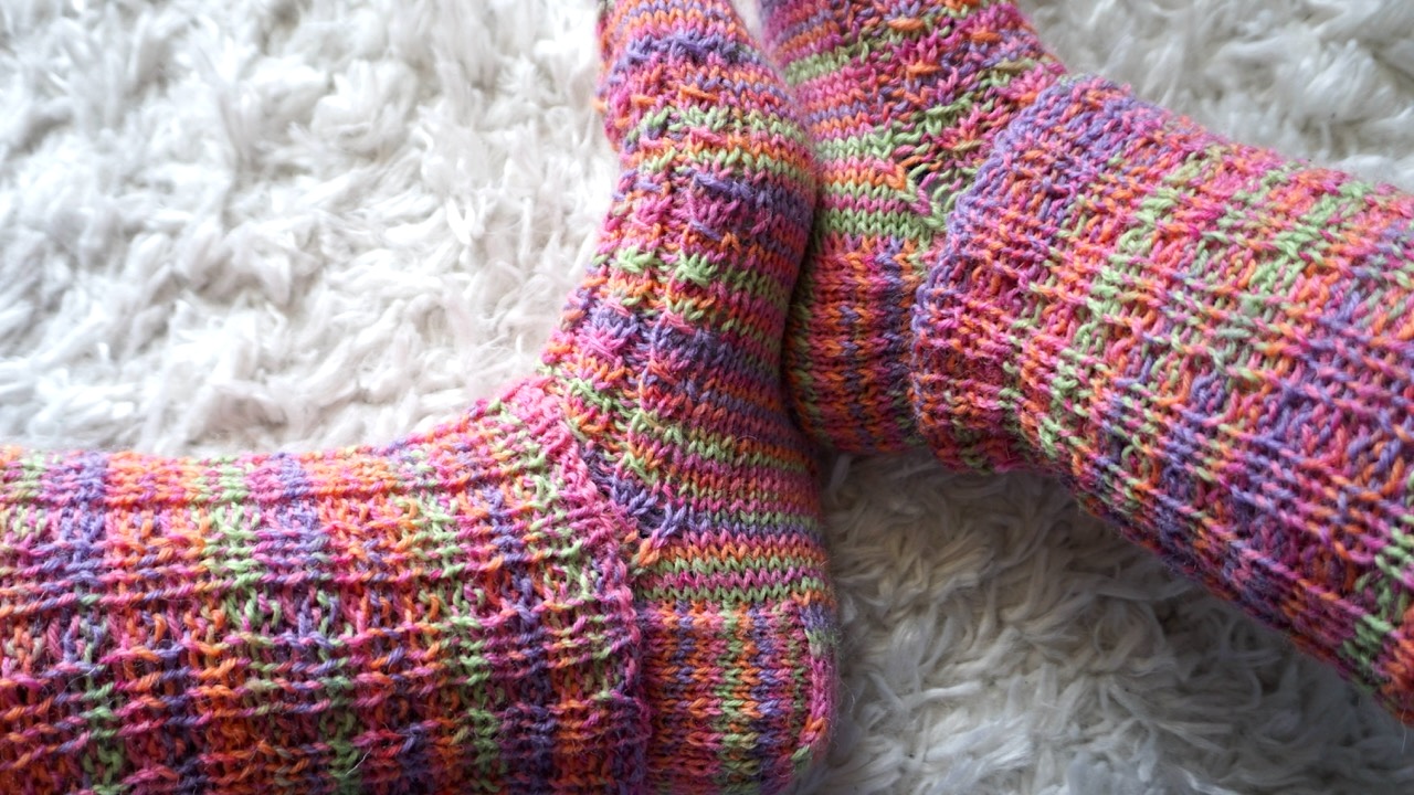 Feet wearing knitted socks in mock cable knit stitch pattern