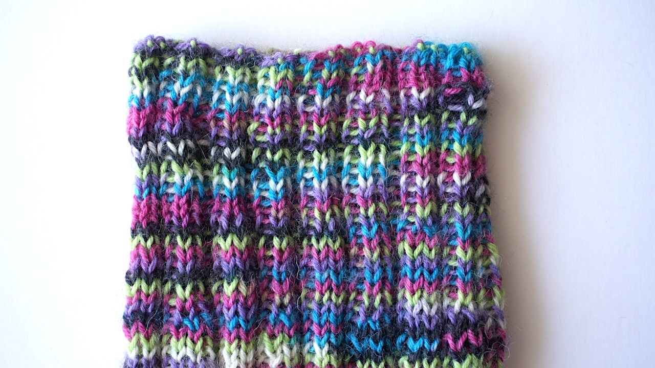 Close-up photo of ribbed turtleneck of a knit dog sweater in multicolored yarn
